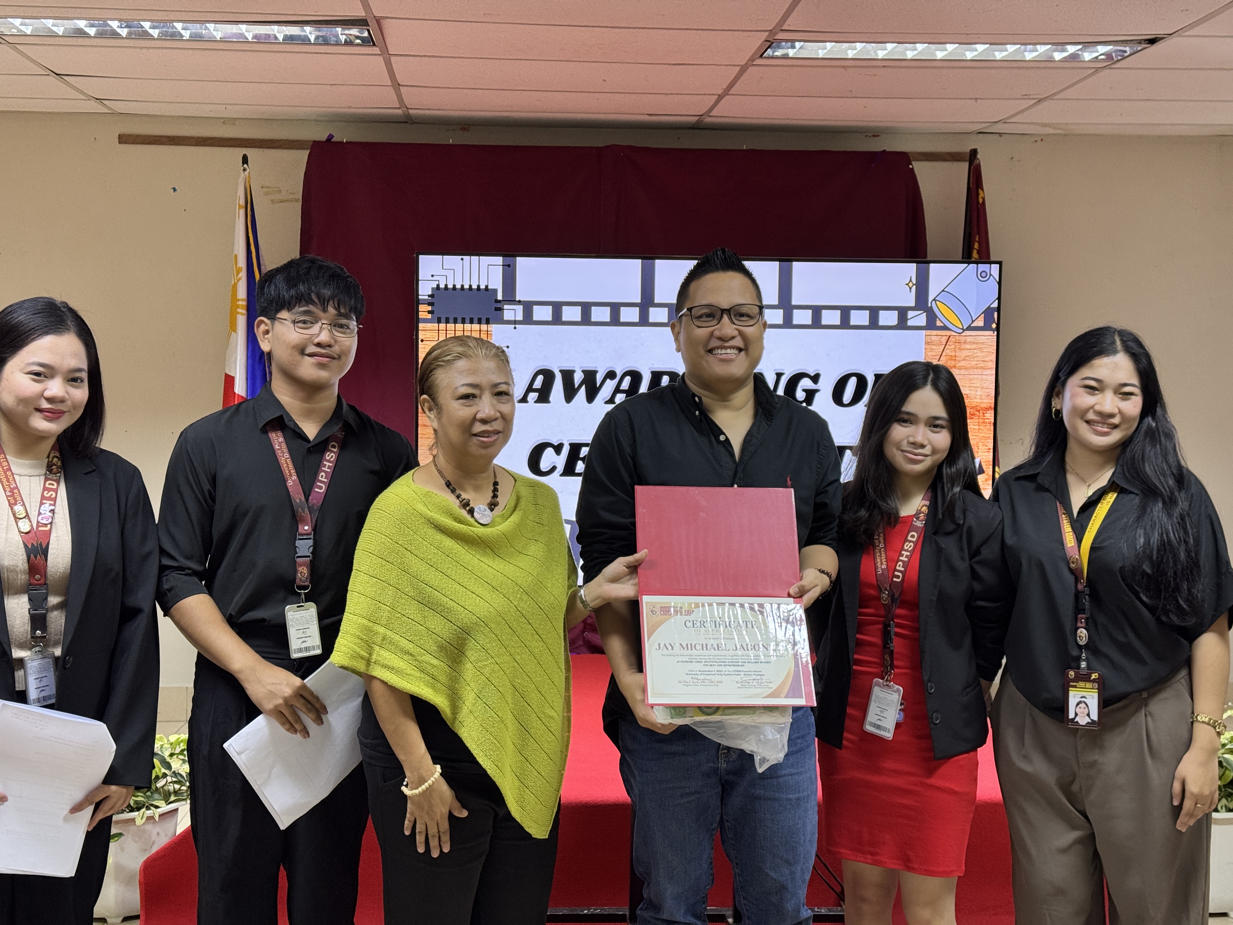 Jay Jaboneta receiving a certificate of appreciation at UPHSD Molino alongside faculty and student representatives